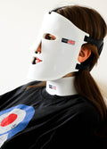 woman wearing red light therapy mask and its neck piece